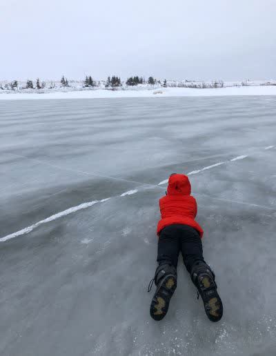 Guest lying on the frozen bay for a low-angle photograph