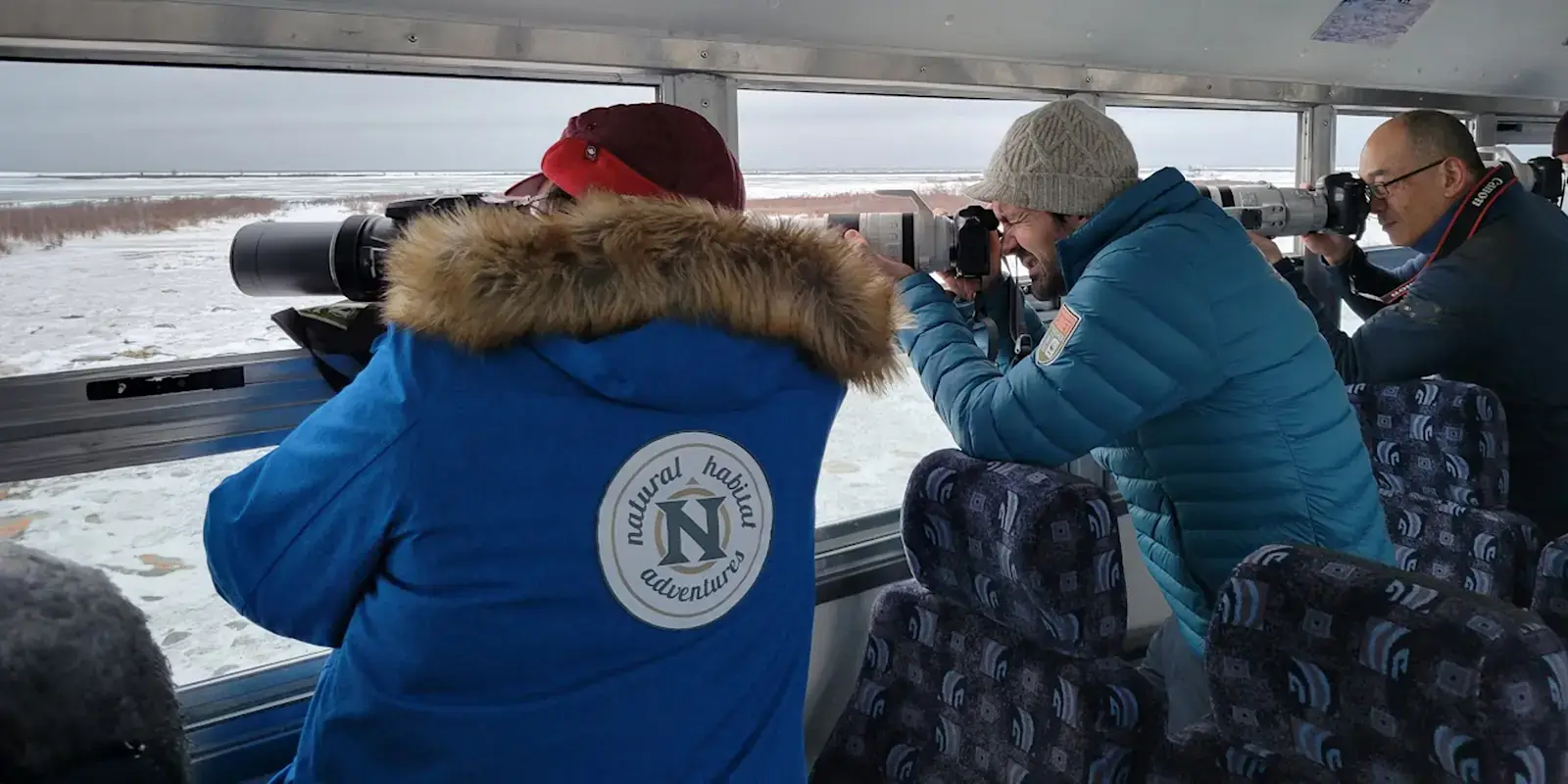 Photographers shooting from the open windows of a Polar Rover